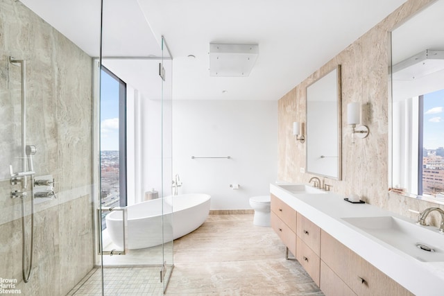 50 Bridge Park Dr Unit 21D, New York City, NY 11201 - bathroom with a soaking tub, double vanity, a stall shower, and toilet