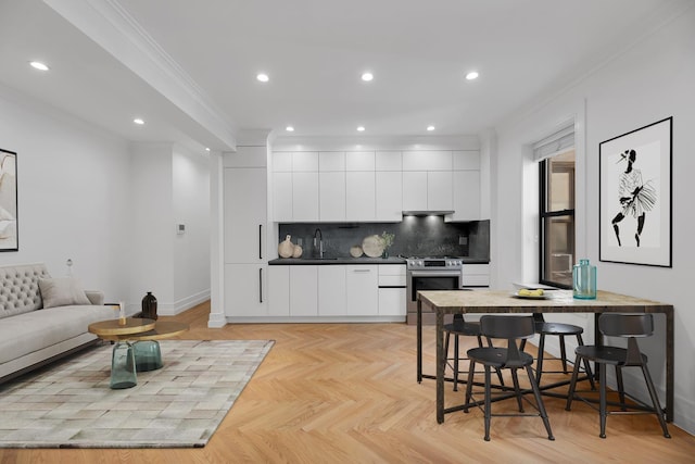 kitchen with stainless steel range with electric cooktop, modern cabinets, crown molding, white cabinets, and backsplash