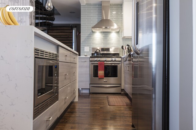 1138 Ocean Ave Unit 8F, New York City, NY 11230 - kitchen with stainless steel appliances, wall chimney range hood, dark wood-style floors, modern cabinets, and backsplash