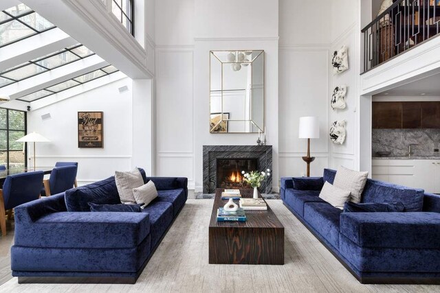 241 E 48th St, New York City, NY 10017 - living area with a decorative wall, visible vents, a high ceiling, and a fireplace