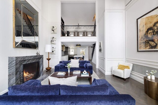 241 E 48th St, New York City, NY 10017 - living area featuring a decorative wall, a towering ceiling, and a premium fireplace