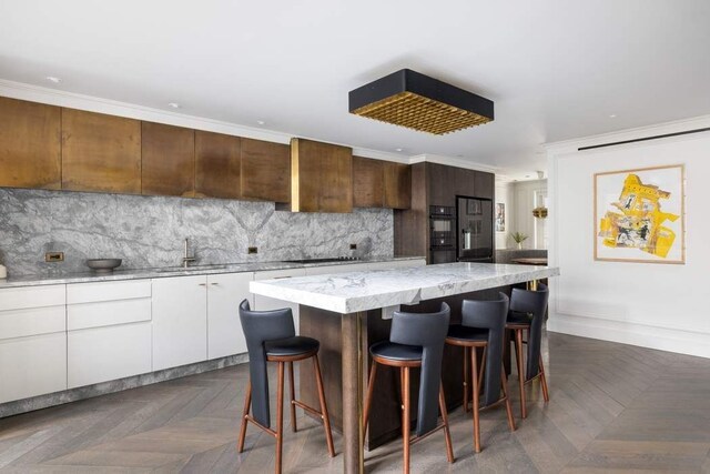 241 E 48th St, New York City, NY 10017 - kitchen featuring tasteful backsplash, a center island, a sink, a kitchen bar, and stovetop