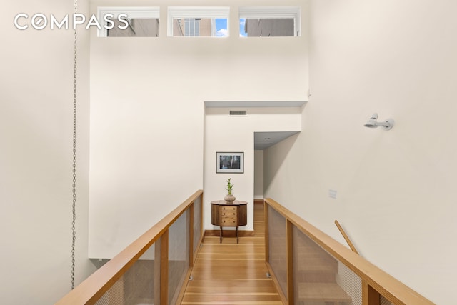 staircase featuring wood finished floors and visible vents