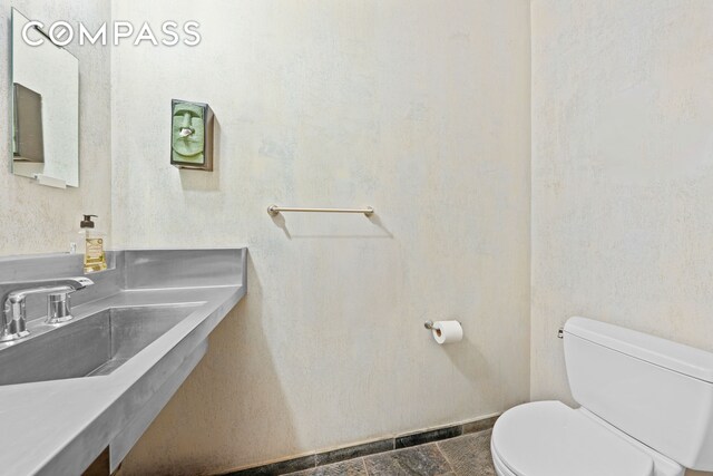 half bath featuring toilet and a sink