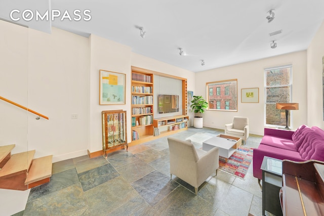 living area featuring visible vents, built in features, and baseboards