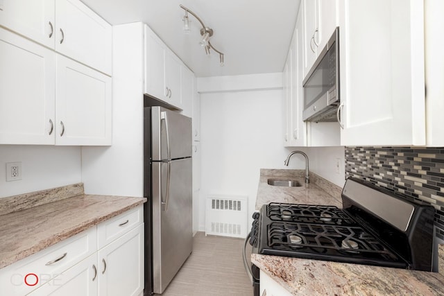 37-31 73rd St Unit 3P, New York City, NY 11372 - kitchen featuring appliances with stainless steel finishes, backsplash, white cabinets, light stone countertops, and radiator