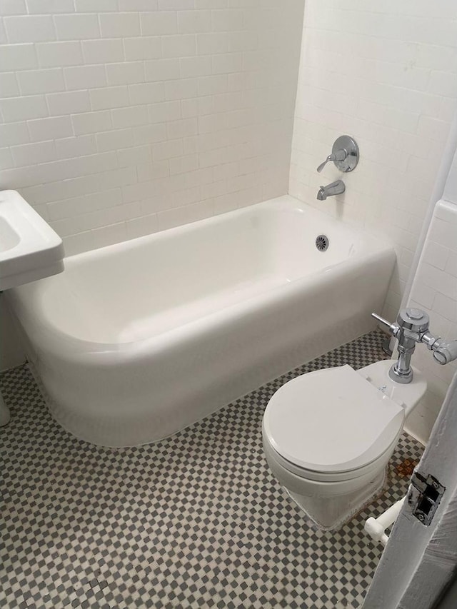 bathroom featuring shower / washtub combination, tile patterned floors, and toilet