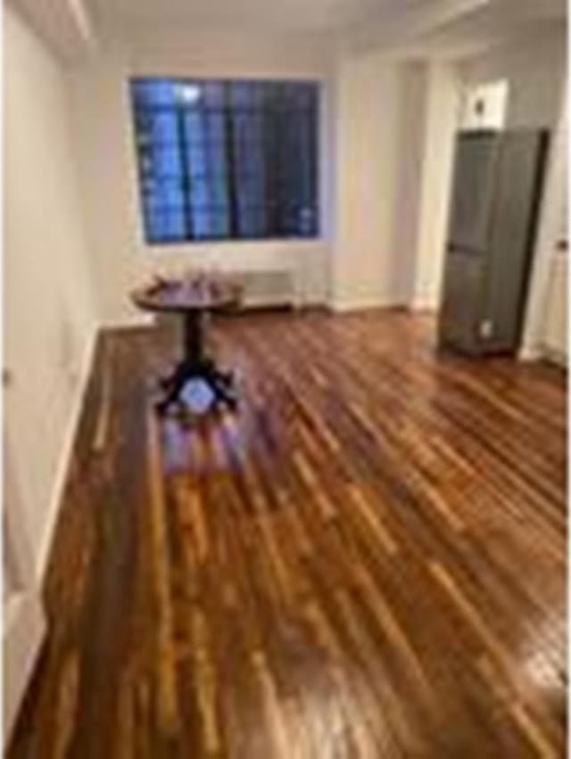 unfurnished living room with baseboards and wood finished floors