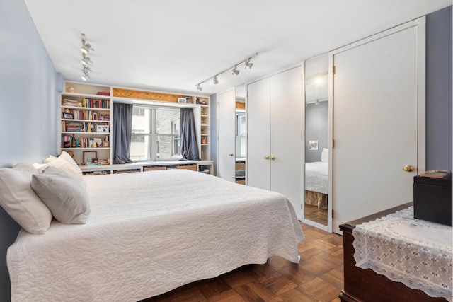 bedroom featuring rail lighting and two closets