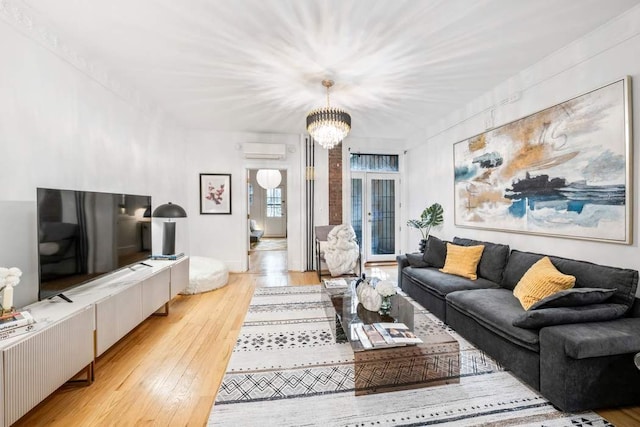 315 W 71st St, New York City, NY 10023 - living room featuring a wall unit AC, light wood-style flooring, and a chandelier