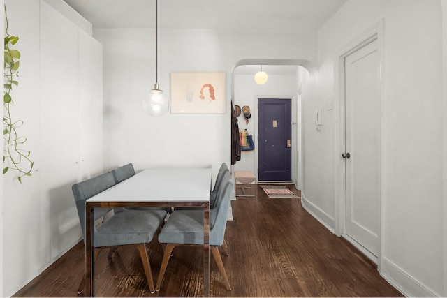 192 E 8th St Unit 6A, New York City, NY 11218 - dining space featuring dark wood-style flooring, arched walkways, and baseboards