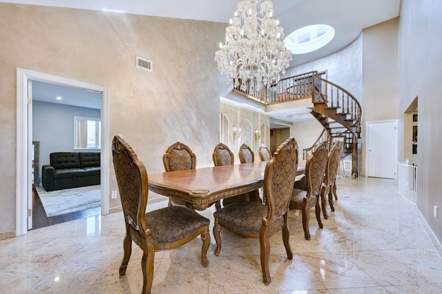 dining room with visible vents, marble finish floor, a towering ceiling, and stairs