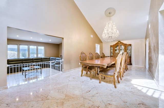 dining area featuring baseboards, high vaulted ceiling, and a chandelier