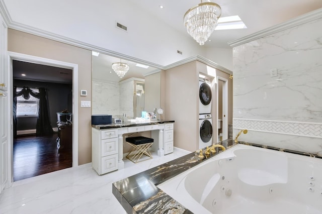 full bathroom with visible vents, marble finish floor, an inviting chandelier, and stacked washer and clothes dryer