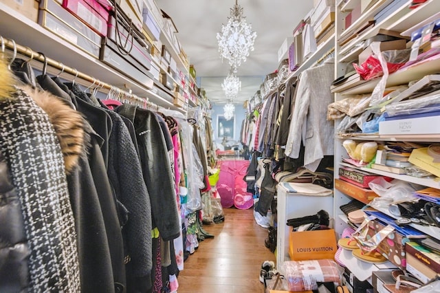 spacious closet featuring a notable chandelier and wood finished floors
