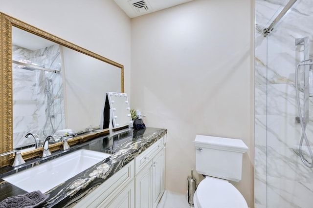 bathroom with visible vents, a sink, toilet, double vanity, and a marble finish shower