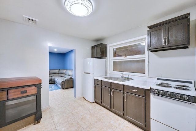 kitchen with a sink, white appliances, visible vents, and dark brown cabinetry