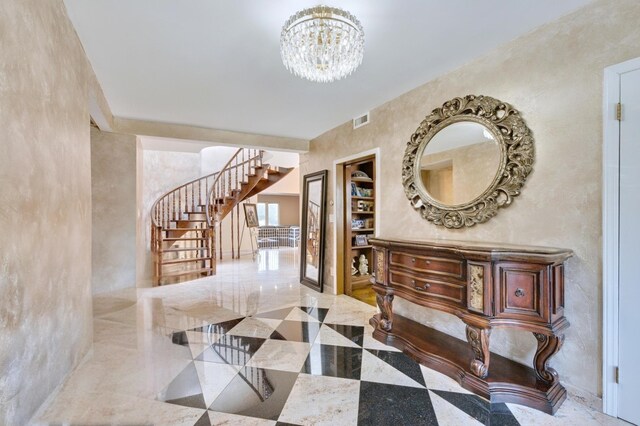 foyer entrance featuring a notable chandelier, stairway, and visible vents