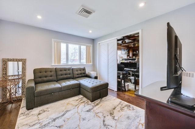 living area with dark wood finished floors, visible vents, and recessed lighting