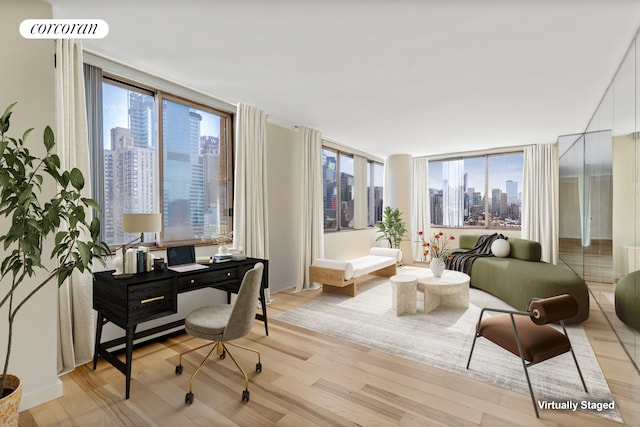 350 W 50th St Unit 28B, New York City, NY 10019 - home office featuring a skyline view and light wood-style flooring