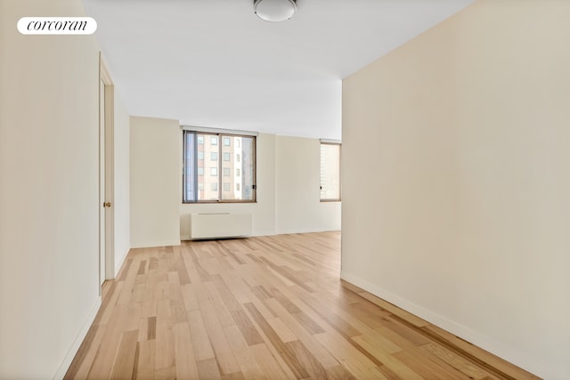 350 W 50th St Unit 28B, New York City, NY 10019 - spare room with light wood-style flooring, radiator heating unit, and baseboards