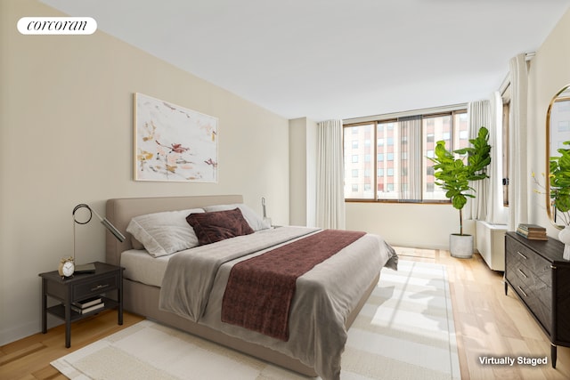 350 W 50th St Unit 28B, New York City, NY 10019 - bedroom with light wood finished floors and radiator heating unit