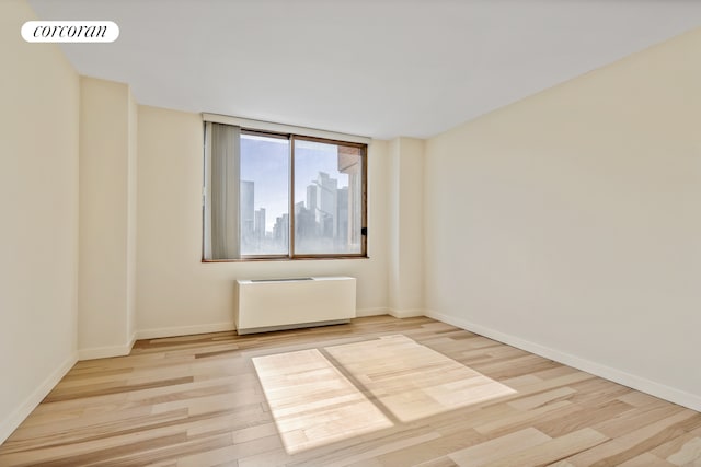 350 W 50th St Unit 28B, New York City, NY 10019 - empty room with wood finished floors, radiator, and baseboards