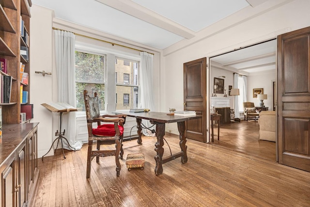 45 E 62nd St Unit 2B, New York City, NY 10065 - dining room featuring beam ceiling, hardwood / wood-style floors, and a fireplace