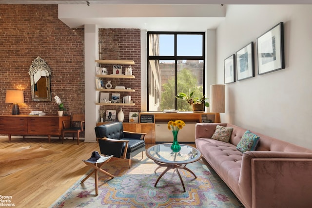 77 Bleecker St Unit 520, New York City, NY 10012 - sitting room with wood finished floors, brick wall, and a towering ceiling