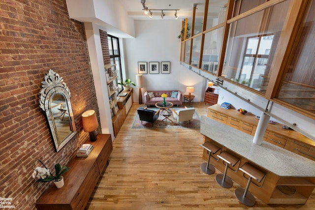 77 Bleecker St Unit 520, New York City, NY 10012 - living room with wood finished floors, plenty of natural light, brick wall, and rail lighting