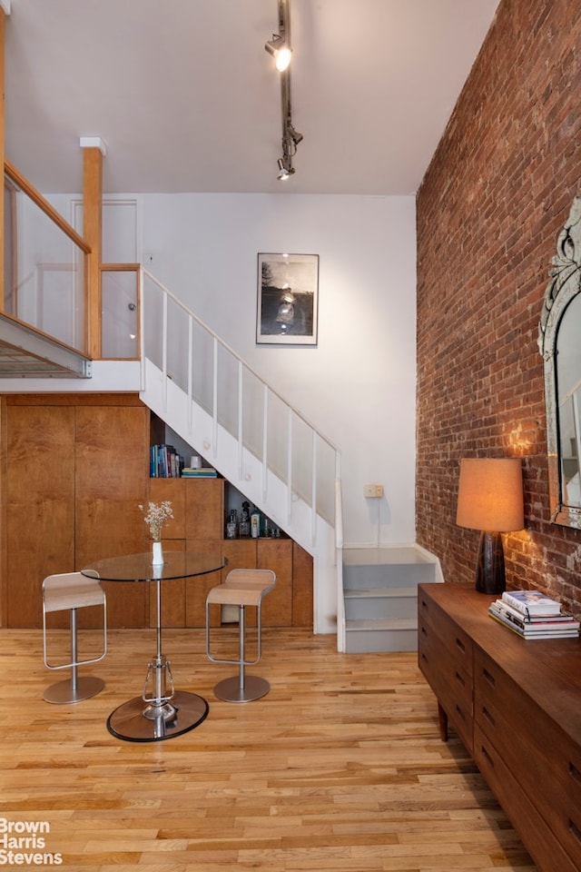 77 Bleecker St Unit 520, New York City, NY 10012 - sitting room with stairs, wood finished floors, brick wall, and rail lighting