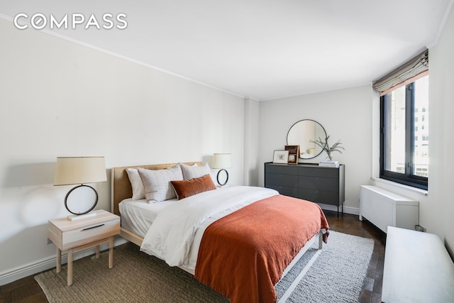 bedroom with baseboards, ornamental molding, and radiator