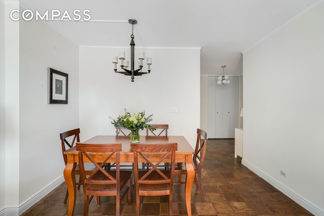 dining space featuring crown molding, baseboards, and a notable chandelier