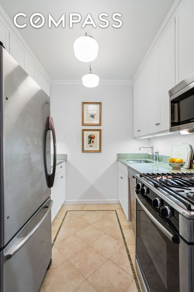 kitchen featuring white cabinetry, baseboards, ornamental molding, stainless steel appliances, and light tile patterned flooring
