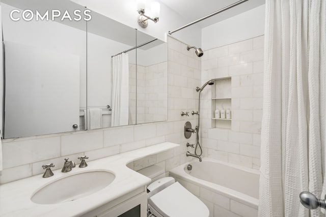 full bathroom with backsplash, toilet, tiled shower / bath, and vanity