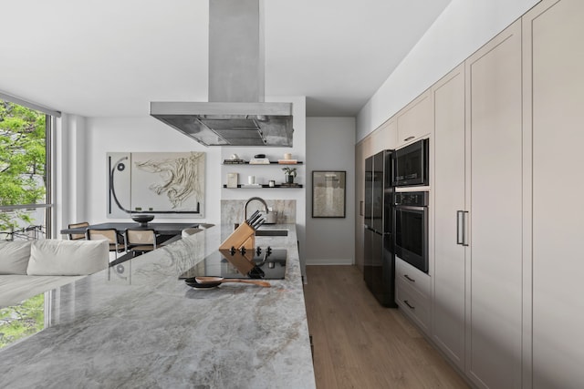 kitchen with island exhaust hood, black appliances, a sink, wood finished floors, and open shelves