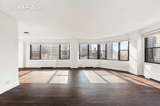 interior space featuring baseboards, radiator heating unit, and wood finished floors