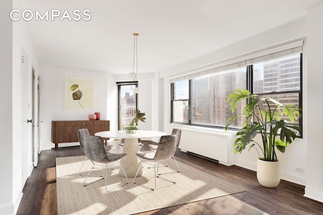 dining area with a healthy amount of sunlight, baseboards, and dark wood-style floors
