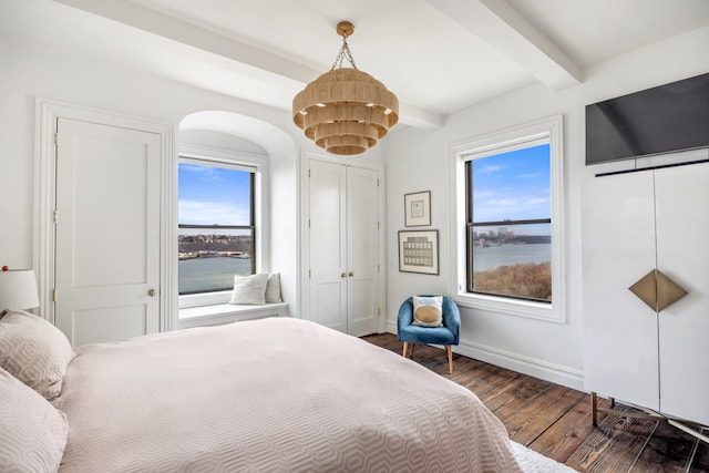 bedroom featuring dark wood-style flooring, a chandelier, beamed ceiling, baseboards, and arched walkways