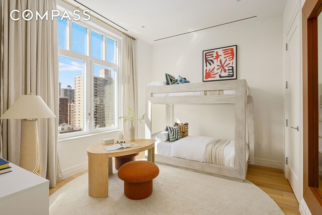 15 W 96th St Unit 11, New York City, NY 10025 - bedroom with a city view, light wood-style flooring, multiple windows, and baseboards