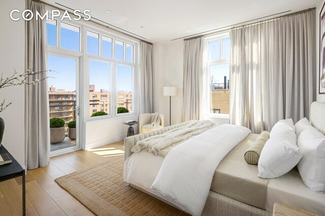 15 W 96th St Unit 11, New York City, NY 10025 - bedroom with multiple windows, access to exterior, and hardwood / wood-style floors