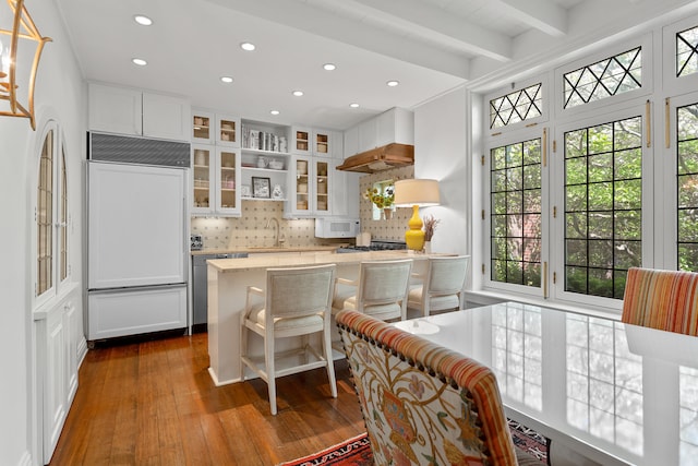 27 Perry St, New York City, NY 10014 - kitchen with paneled fridge, tasteful backsplash, hardwood / wood-style floors, healthy amount of natural light, and recessed lighting