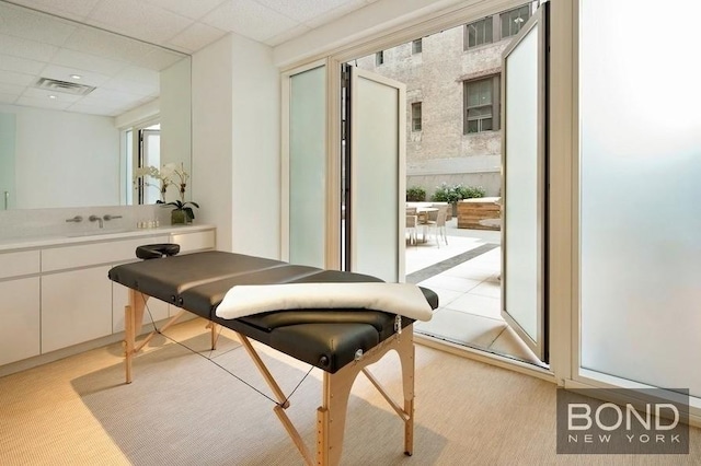 300 E 23rd St Unit 7H, New York City, NY 10010 - doorway with light carpet, a sink, and a paneled ceiling