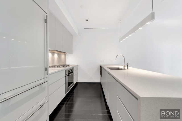 300 E 23rd St Unit 7H, New York City, NY 10010 - kitchen featuring a sink, appliances with stainless steel finishes, modern cabinets, white cabinets, and a peninsula