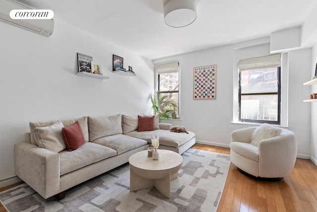 240 E 24th St Unit 1E, New York City, NY 10010 - living area with a wall mounted AC, light wood-style floors, and baseboards