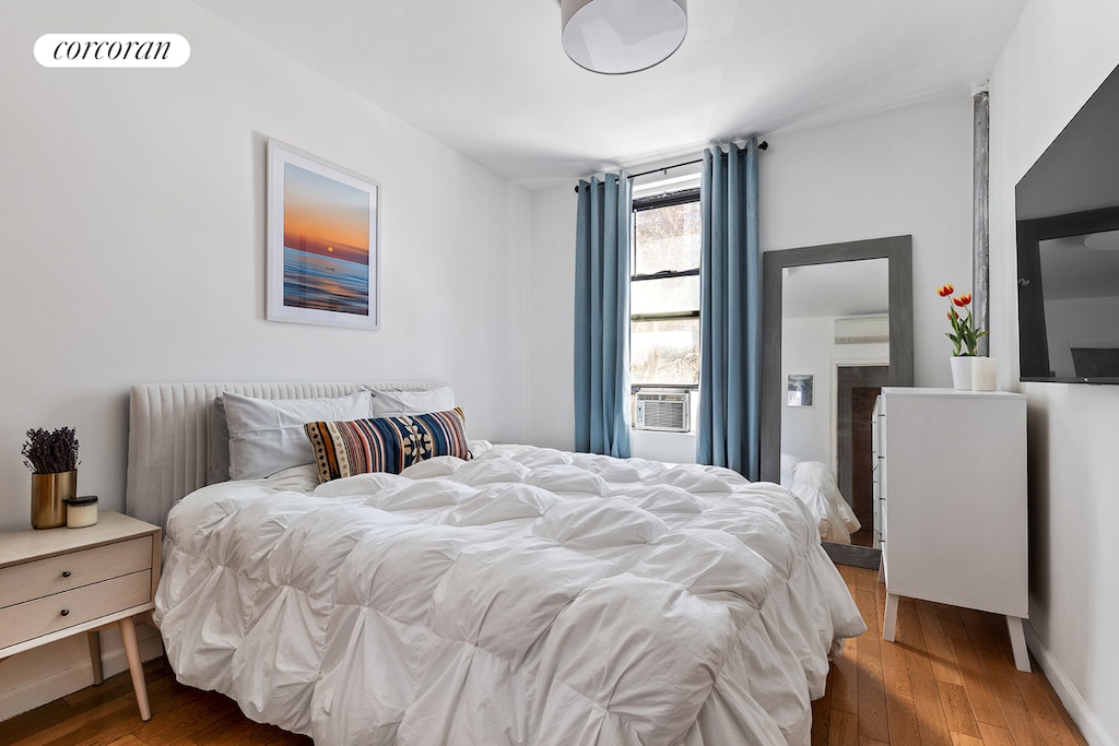 240 E 24th St Unit 1E, New York City, NY 10010 - bedroom featuring wood finished floors and cooling unit