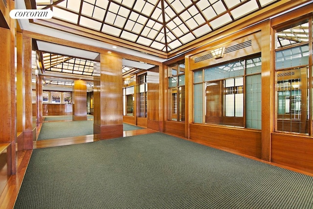 community lobby featuring a high ceiling and wood walls