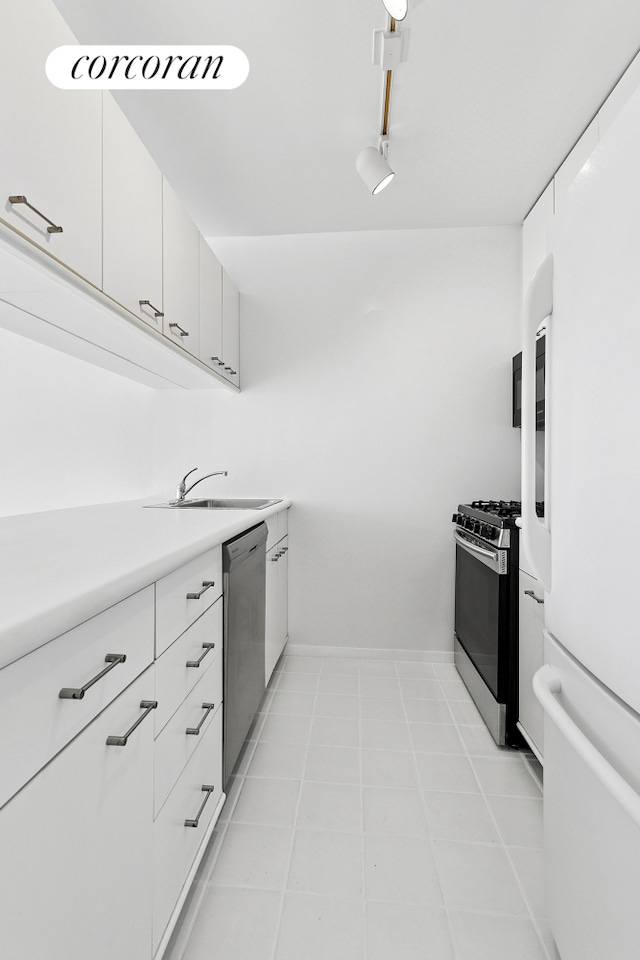 kitchen with stainless steel appliances, a sink, light countertops, and white cabinetry