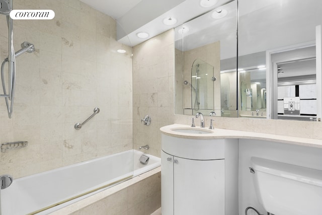 full bath with toilet, tiled shower / bath combo, and vanity