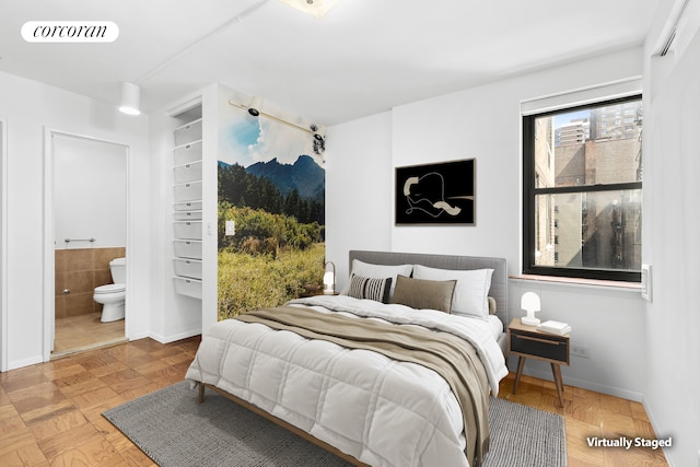 bedroom with baseboards, visible vents, and ensuite bath